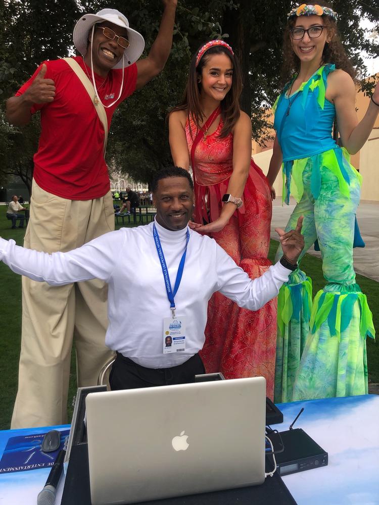 DJ booth with stilt-walker entertainers at an outdoor event
